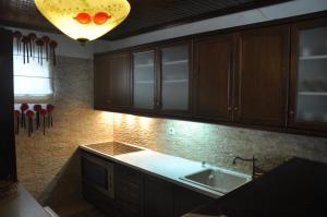 a kitchen with wooden cabinets and a sink and a light at Kastraki Vacations House in Dimitsana