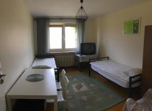 a small room with two beds and a table at Noclegi Tulipan in Konin