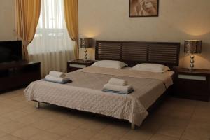 a bedroom with a large bed with towels on it at Delfin in Koblevo