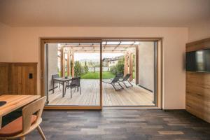 un soggiorno con porta scorrevole in vetro che conduce a un patio. di Weingut Moser Apartments a Caldaro