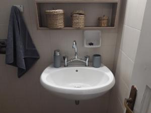 a white sink in a bathroom with towels and baskets at Ammos papanero in Agios Ioannis Pelio +90 photos