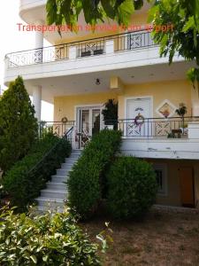 een wit gebouw met een trap en een balkon bij Stavros Apartments in Artemida