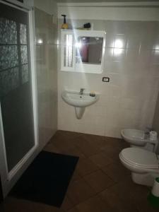 La salle de bains est pourvue d'un lavabo, de toilettes et d'un miroir. dans l'établissement St Francis Apartaments, à Foligno