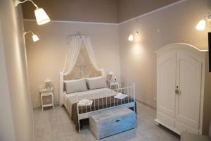 una camera da letto con un letto bianco e una finestra di Villa Erminia a Canicattini Bagni