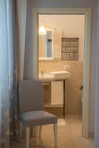 un bagno con una sedia e un lavandino di Villa Erminia a Canicattini Bagni Altre 58 foto