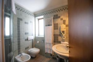 a bathroom with a toilet and a sink at Hotel Giardino in Cannobio +37 photos