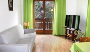 een woonkamer met een bank en een televisie bij Oberjaistenhof in Lana