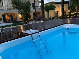 una piscina con scala di fronte a una casa di Viale Villa Arianna, 8 a Castellammare di Stabia
