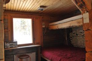 a bedroom with a bed in a cabin with a window at Loma-asunto tunturimaisemassa in Ylikyro +43 photos