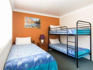 two bunk beds in a room with orange walls at 1 54 Parkes Street in Tuncurry