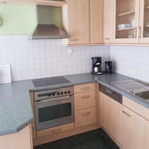 een keuken met houten kasten en een fornuis met oven bij Ferienwohnung in Ostseenähe in Grevesmühlen