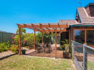 a wooden pergola with a table on a patio at 11 Bay Street - waterfront holiday in Tuncurry