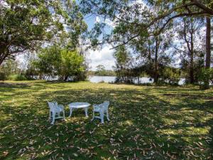 two chairs sitting next to a table in a field at 11 Bay Street - waterfront holiday in Tuncurry