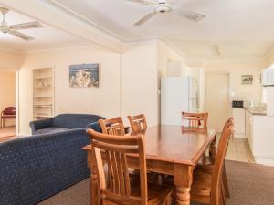 a living room with a table and a blue couch at 11 Peel Street in Tuncurry