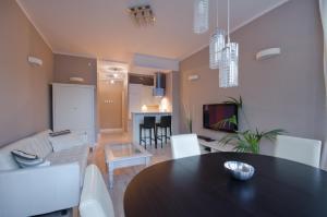 a dining room and living room with a table and chairs at Apartament Molo in Sopot