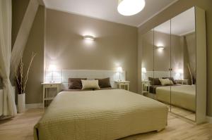 a bedroom with a large bed and a mirror at Apartament Molo in Sopot