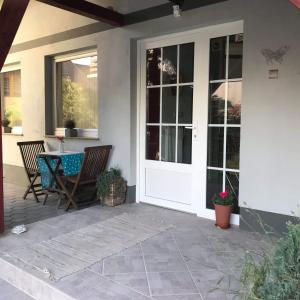 a patio with a white door and a table and chairs at Apartma Peter1a in Begunje na Gorenjskem