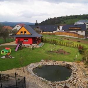 un parque con parque infantil y un edificio con parque infantil en Domek Całoroczny OSTOJA en Istebna