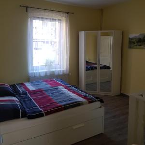 een slaapkamer met een bed, een raam en een spiegel bij Ferienwohnung in Ostseenähe in Grevesmühlen