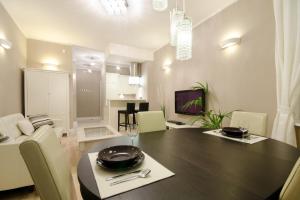 a dining room and living room with a table and chairs at Apartament Molo in Sopot