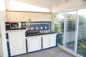 a kitchen with white cabinets and a microwave at Villa Letizia in Campofelice di Roccella