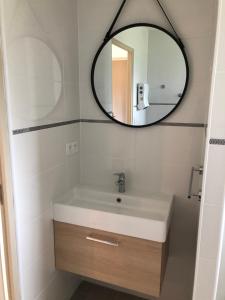 a bathroom with a sink and a mirror at La petite maison des gîtes de Joséphine in Saint-Dyé-sur-Loire