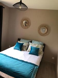a bedroom with a bed with blue pillows at La petite maison des gîtes de Joséphine in Saint-Dyé-sur-Loire