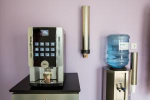 a drink dispenser with a cell phone and a water container at MOTEL Schlegel in Erwitte