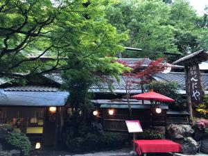 a building with a red umbrella in front of it at Benidaruma - Dango in Kyoto