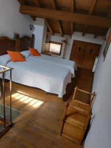 ピエドライタにあるCasa Rural El Zapatero de Sexifirmoのウッドフロアのベッドルーム1室(白いベッド1台付)