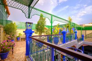 a balcony with a blue fence and flowers at Hotel Central Palace in Marrakech