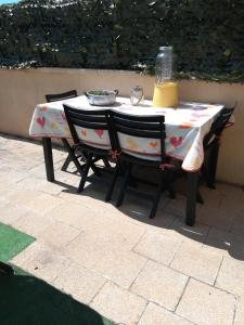 チェリアーレにあるAppartamento al mareのテーブルと椅子2脚(テーブルクロス付)
