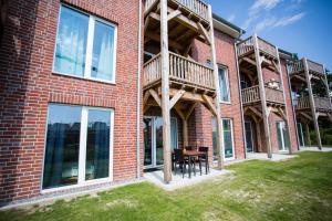 a red brick building with a table on the grass at Strandchalet Elmo II in Wremen