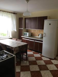 uma cozinha com uma mesa e um frigorífico branco em Noclegi Tulipan em Konin