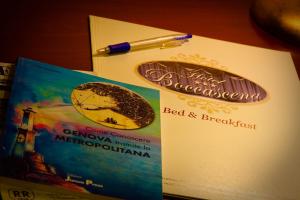 a book with a cookie and a pen on a table at Hotel Boccascena in Genoa