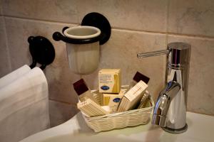 a basket of soap and butter on a bathroom sink at Hotel Boccascena in Genoa