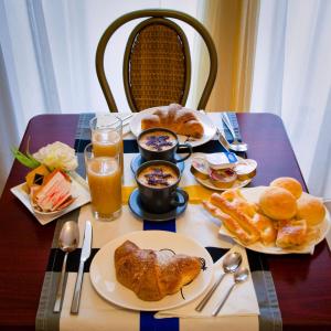 a table with plates of food and drinks on it at Hotel Boccascena in Genoa