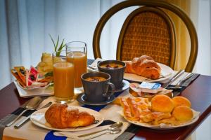 a table topped with plates of food and drinks at Hotel Boccascena in Genoa