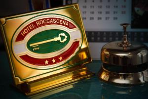 a golden trophy on a table next to a bottle of whiskey at Hotel Boccascena in Genoa