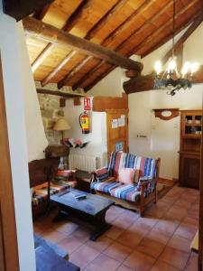sala de estar con sofá y mesa en Casa Rural La Pontezuela Arriba, en Navarredonda de Gredos
