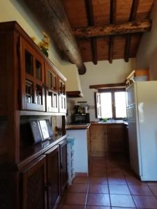 cocina con nevera blanca y ventana en Casa Rural La Pontezuela Arriba, en Navarredonda de Gredos