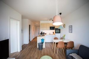 a living room and kitchen with a table and chairs at Strandchalet Elmo II in Wremen