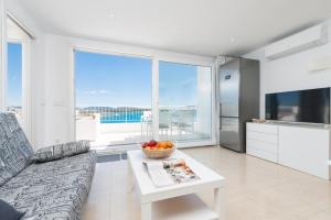 uma sala de estar com um sofá e uma mesa em Luisamar Sea View em Manacor