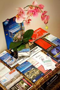 a table topped with books and a vase with a flower at Hotel Boccascena in Genoa