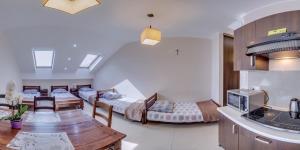 a room with two beds and a table and a kitchen at Folwark Żabowo in Glinojeck