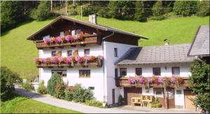 a large white house with flower boxes on it at Alpenbauernhof Gröbenhof in Fulpmes