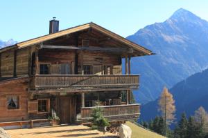a log cabin with mountains in the background at Olympia-Relax-Hotel Leonhard Stock in Finkenberg