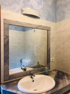 ein Badezimmer mit einem Waschbecken und einem großen Spiegel in der Unterkunft Apartments Vidović in Čežarji