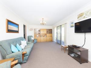 a living room with a couch and a tv at Capeview in Forster