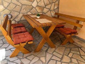 drewniany stół i dwa krzesła siedzące obok stołu w obiekcie Žanjice Luxury Suite w mieście Luštica